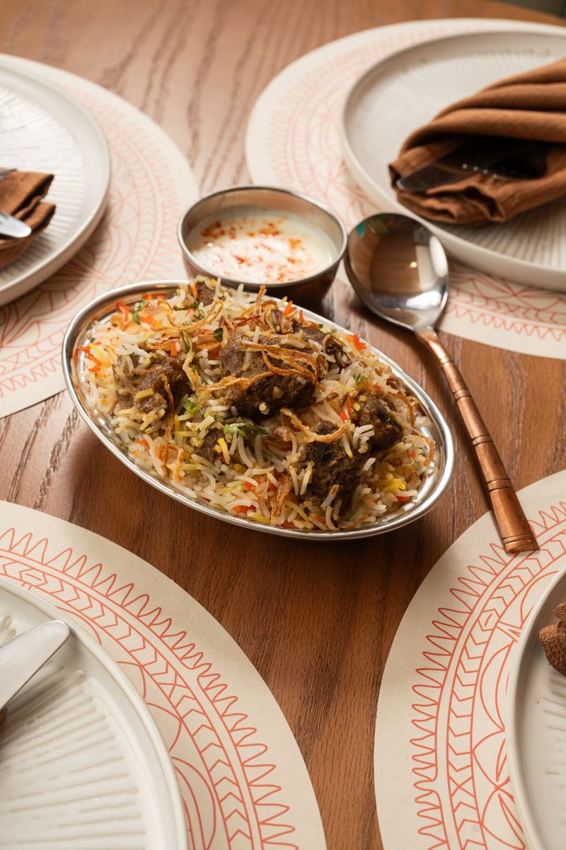 Mutton biryani with fragrant basmati rice, fried onions, and raita